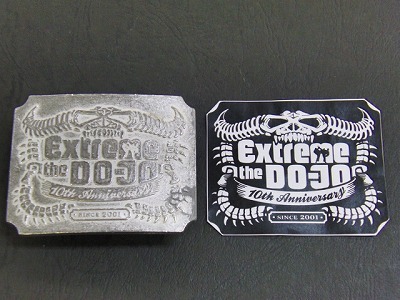 金具職人手作り、ブランドロゴ入り、オリジナルデザインのベルトバックルのオーダーメイド  Original Belt Buckle fittings    メタルハウスでは、オリジナルのボタン、ホック、チャーム、ネームプレートと、さまざまなオリジナル金具の依頼を受けます が、最近では、会社の社員用に、結婚式の記念品として、またセールスプロモーションの販促品としてなど、沢山の業種のお客様向けにオリジナル金具を作らせ ていただいています。     今回は建設業を営んでいらっしゃるお客さまから、社員用のオリジナルのバックル金具と、ベルトの革部分の縫製（完成品）と、イベント会社さま向けにＤＯＪＹＯ＝道場用のオリジナルバックルを作りました。