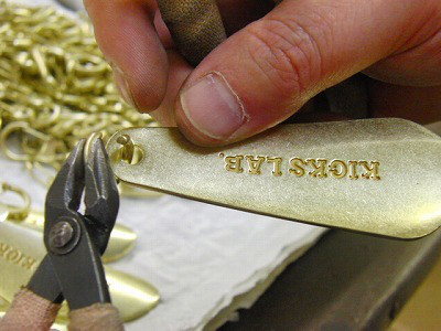真鍮製靴べらキーホルダーに手作業でパーツを取り付け