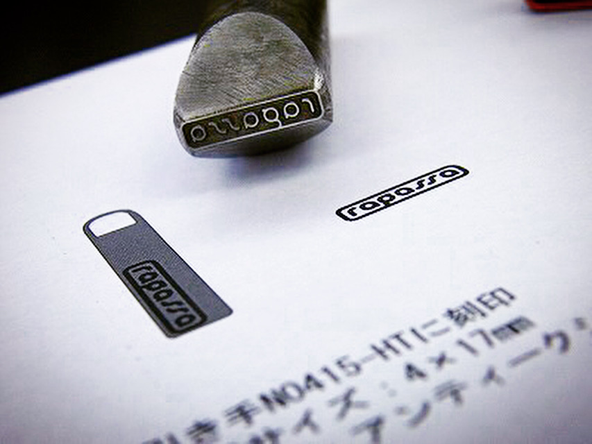 ブランドロゴを彫刻した、オーダーメイドの刻印金具。よく見ると分かりますが、スタンプと同じく文字を逆さまに彫刻しています。