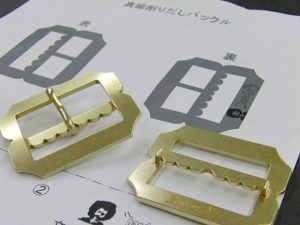 職人オーダーメイド、真鍮製、オリジナルロゴ入りベルトバックルの製作 Original Belt Buckle Fittings メタルハウスでは、さまざまお客様から、さまざまな用途に向けて、完全オーダーメイドのバックルを作ります。真鍮製などの素材のリクエストから、ブランドロゴ、ロットなどを考慮して、鋳物、プレス、削り出しなど、、お客様のイメージやデザインを形にする、最適な製法にて、オリジナルのバックルを製作していきます。