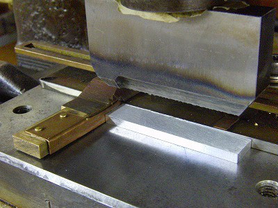 削り出したアルミニウムの表面を磨き出し、その上に富士通さまから依頼されている文字とモチーフを鋼製の刻印（日本刀と同じ材料）にて手作業にて押して行きます。