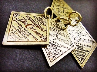 オリジナルブランドロゴ、ネーム入り特注ホック、かしめ、ボタン、チャーム金具のオーダー メタルハウス アクセサリー オーダーメイド 記念品 プレゼント ギフト ノベルティー 金具 金属